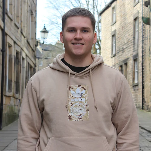 young man in the street with a brown jumper