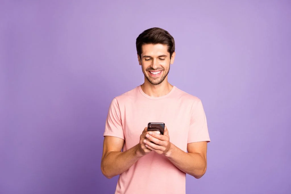 man smilling looking at his phone