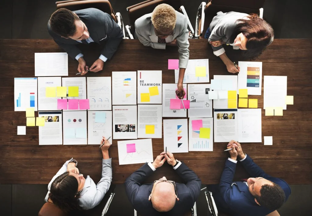 people sat around a table in meeting strategising