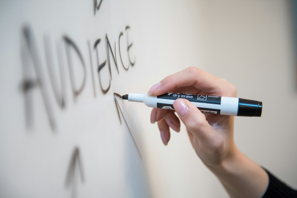person writing in a white board