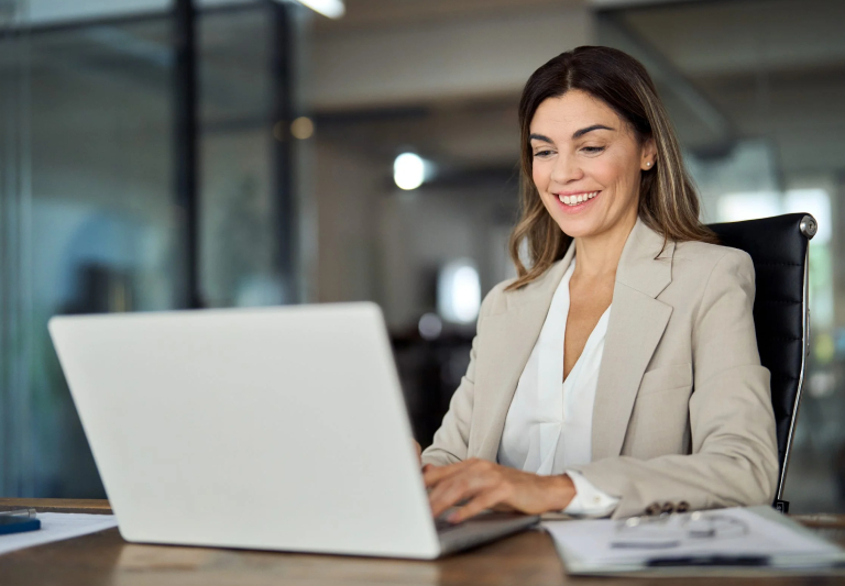 woman smiling looking to a laptop