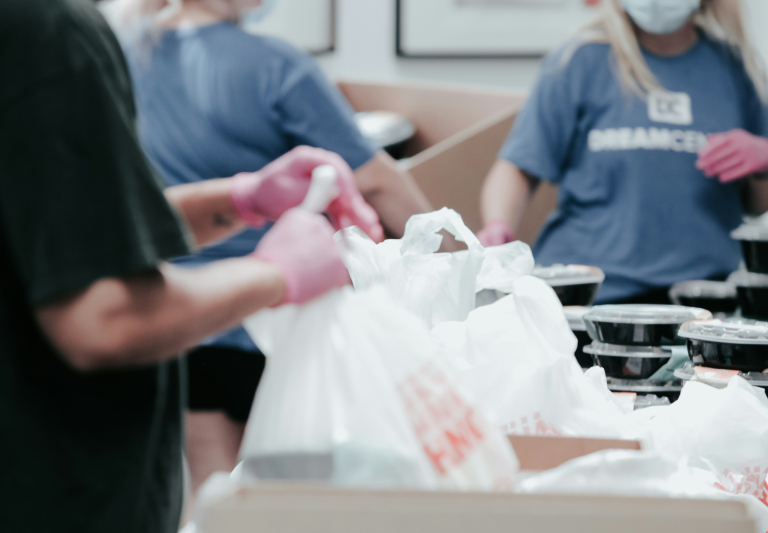 people with pink gloves manipulating plastic bags