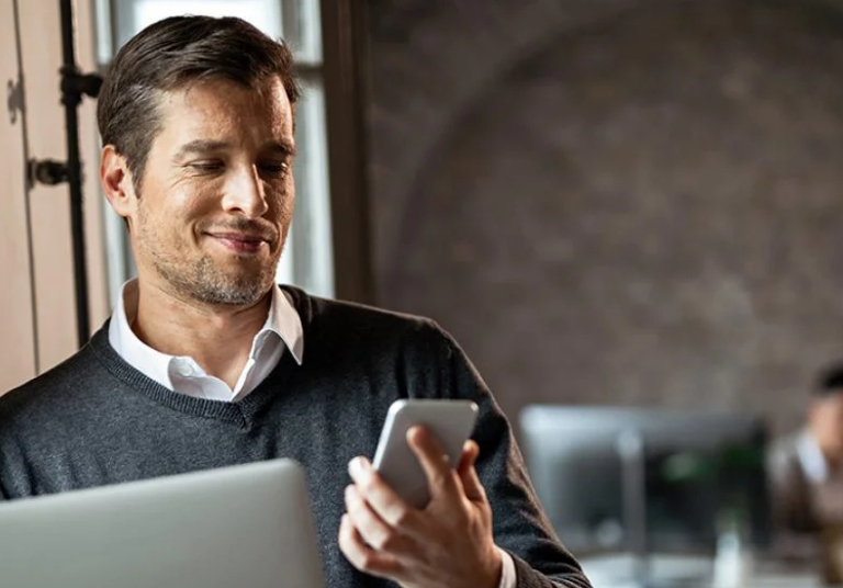 man holding a phone and smiling