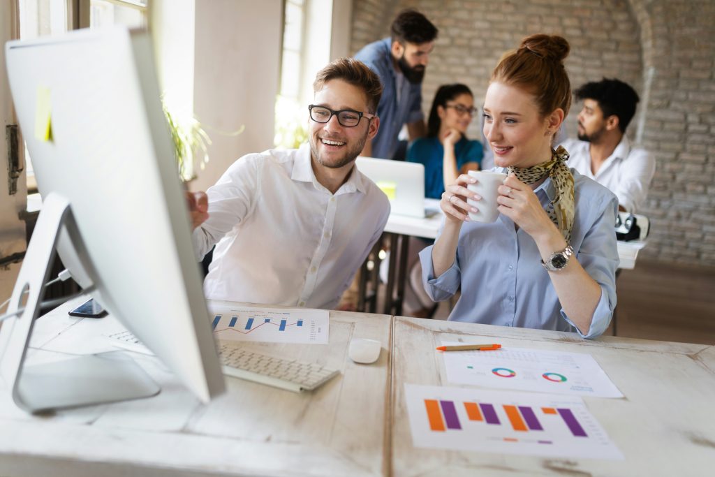 two people smiling in a office environment